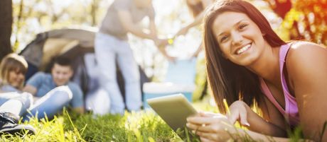 Junge Frau mit Laptop im Gras